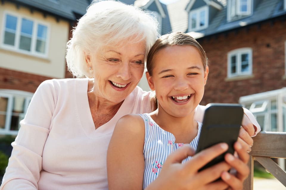 Young girl and elderly lady looking at phone screen