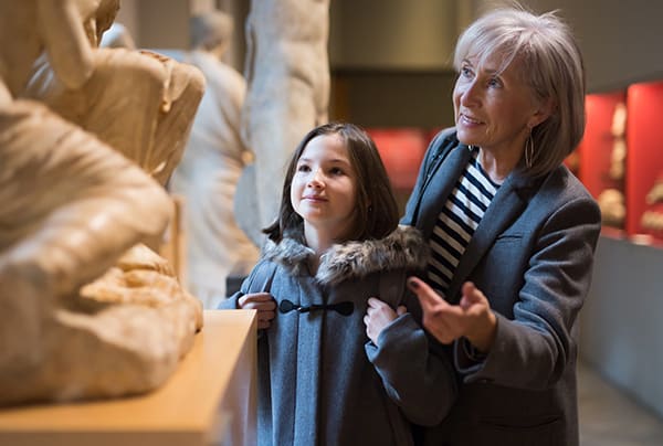 A senior woman and a young girl admiring a sculpture