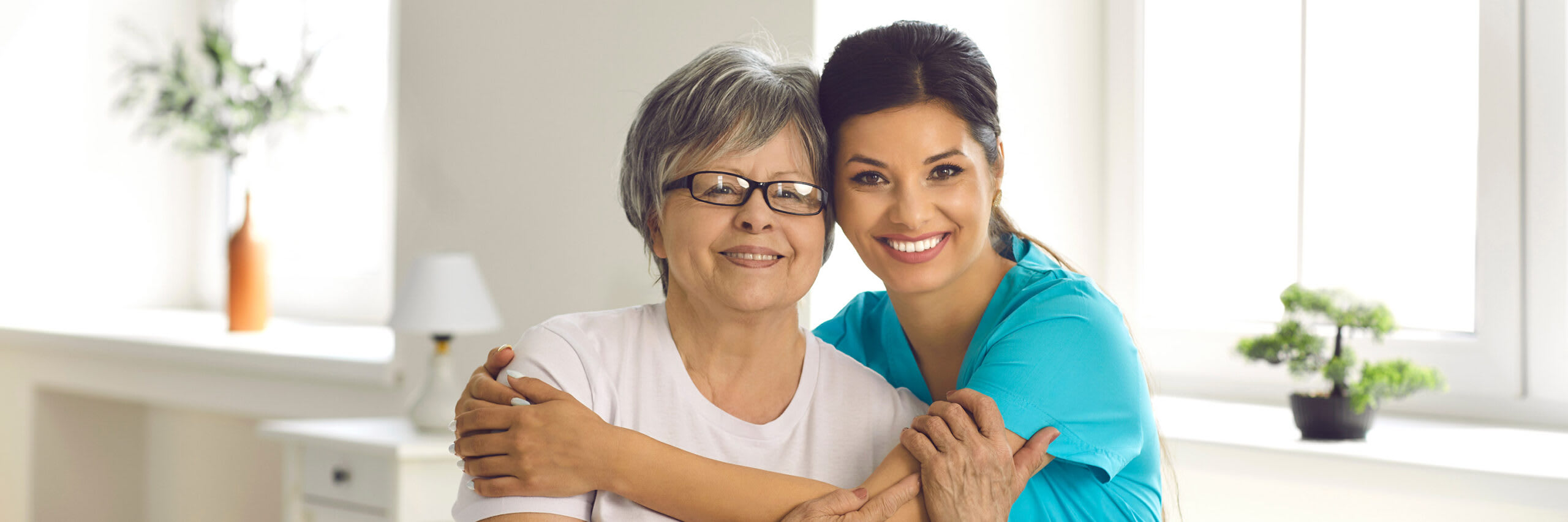 A palliative caregiver supportively embracing a senior woman