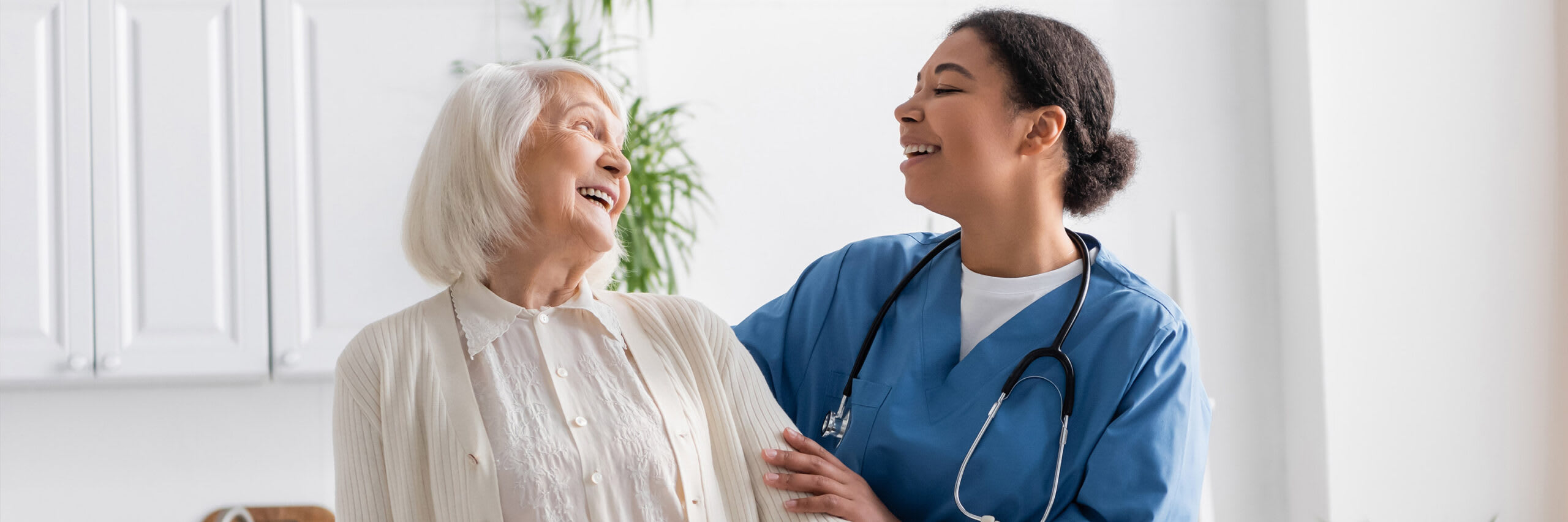 A caregiver smiling while in conversation with a senior