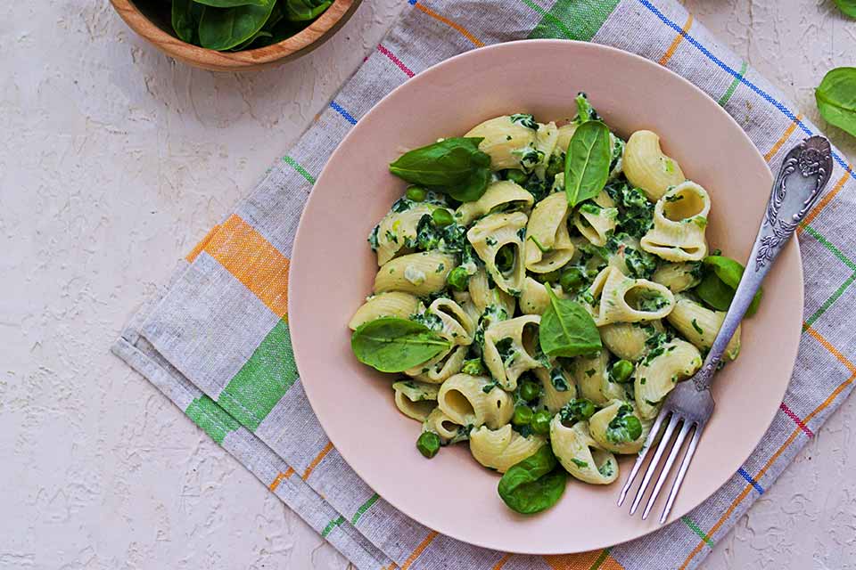 Peas and pasta on a pink plate