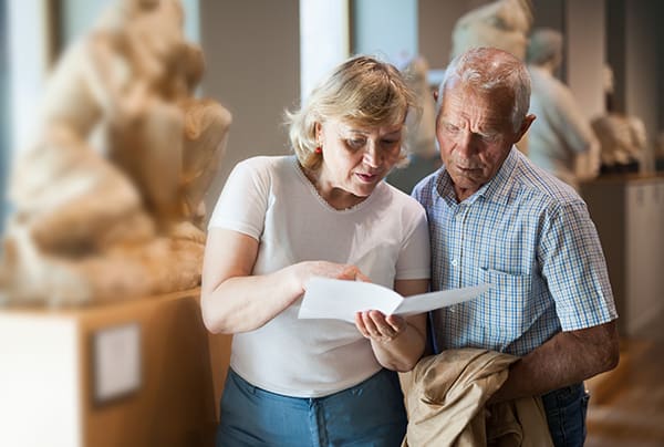 A senior couple reading from a pamphlet while at a museum