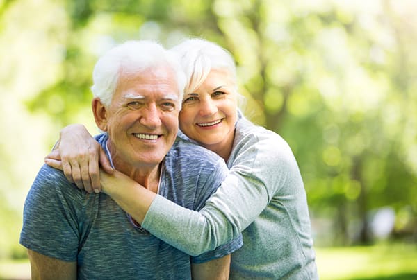 A senior couple embracing while outdoors