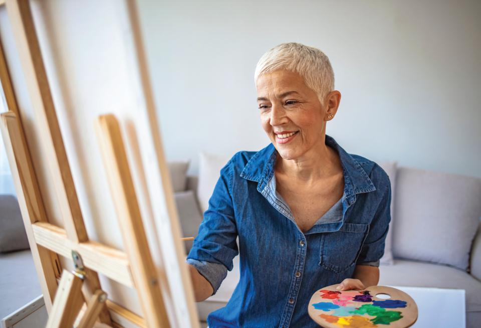 Older woman paints at an independent living community.