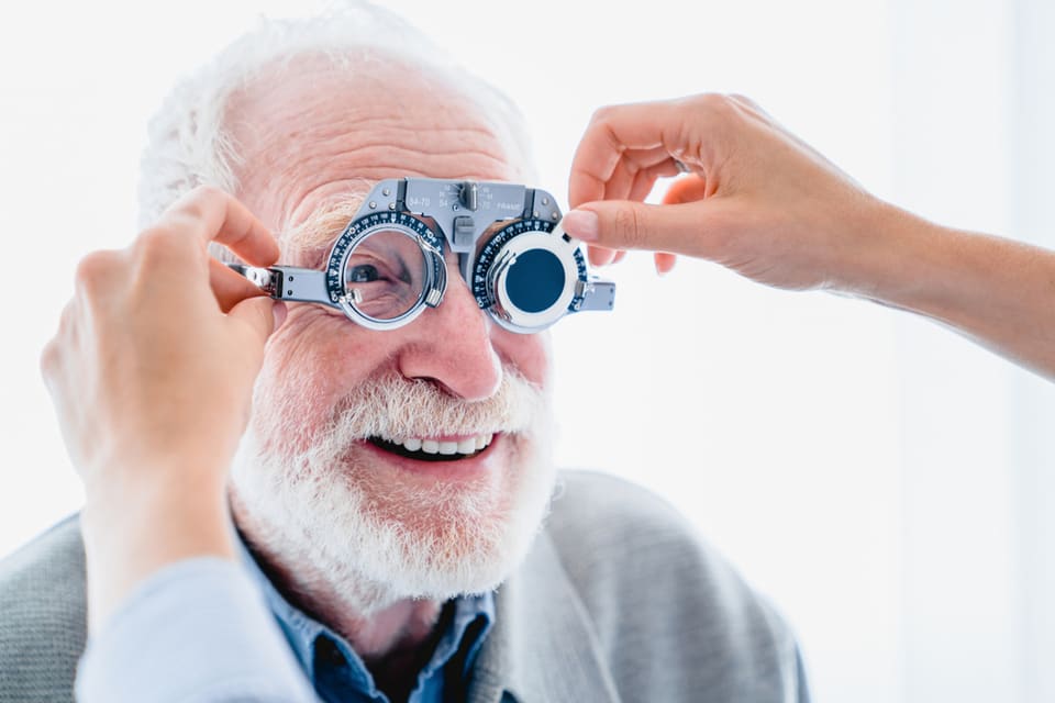 A senior man gets an eye test at the doctor.
