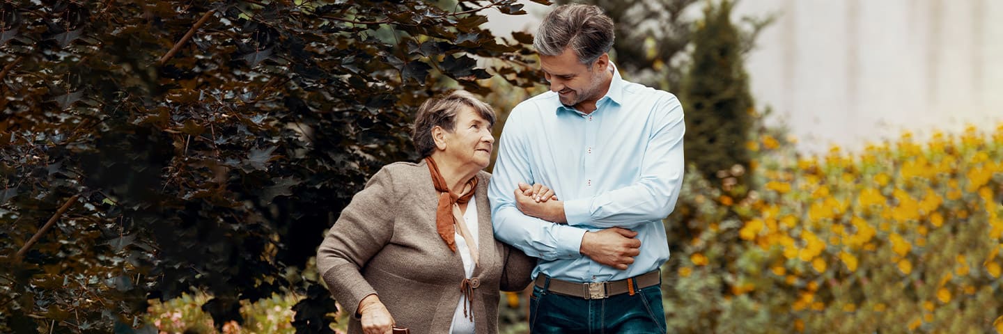 Son and senior mother outside on a walk