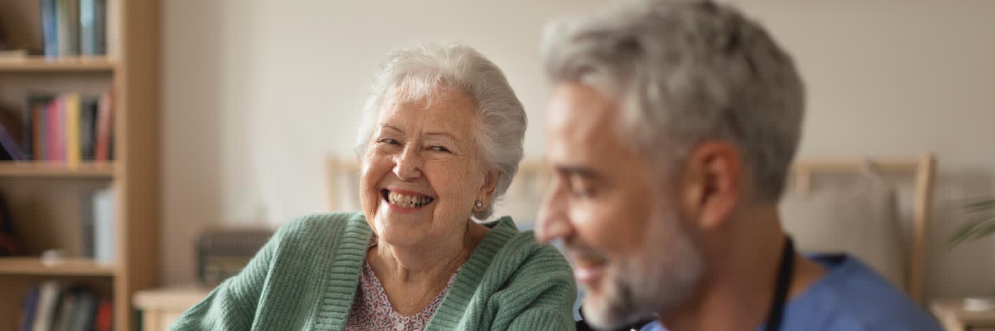 Elderly woman smiling at medical professional