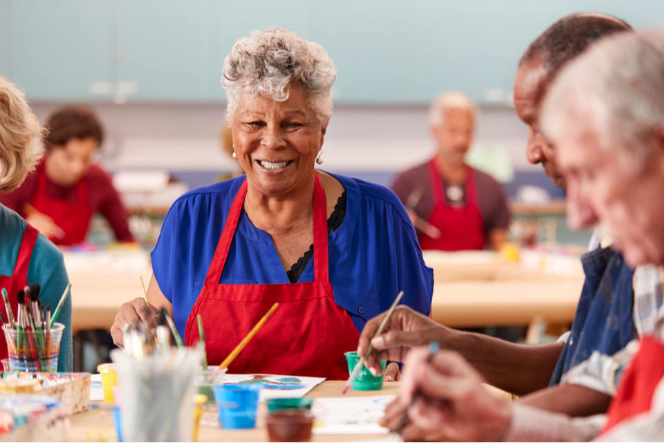 Group of adults enjoying art activities at a memory care day center.