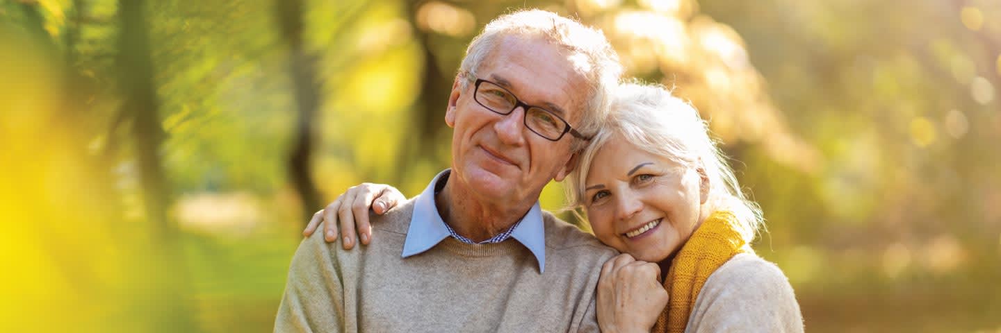 Elderly couple posing for photo outside