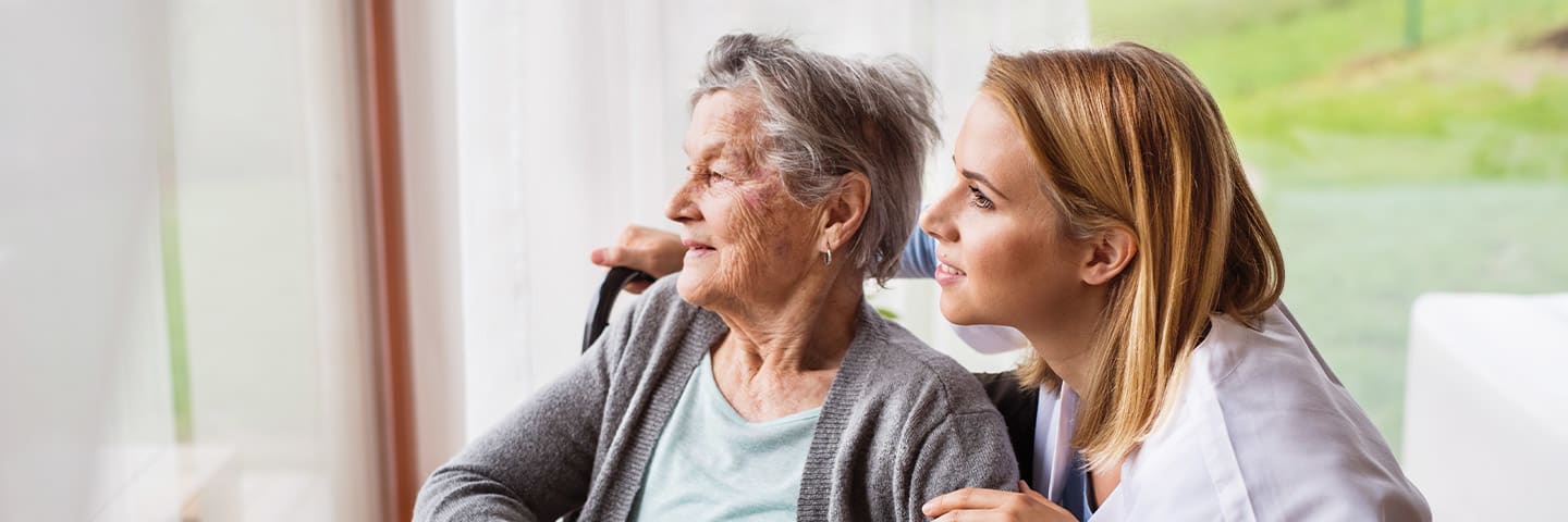 Senior and caregiver looking outside