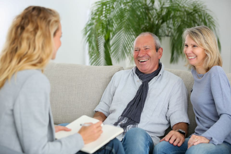A senior couple interviewing with an assisted living nurse