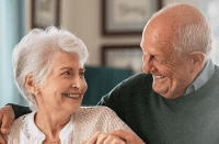 Elderly couple smile at one another