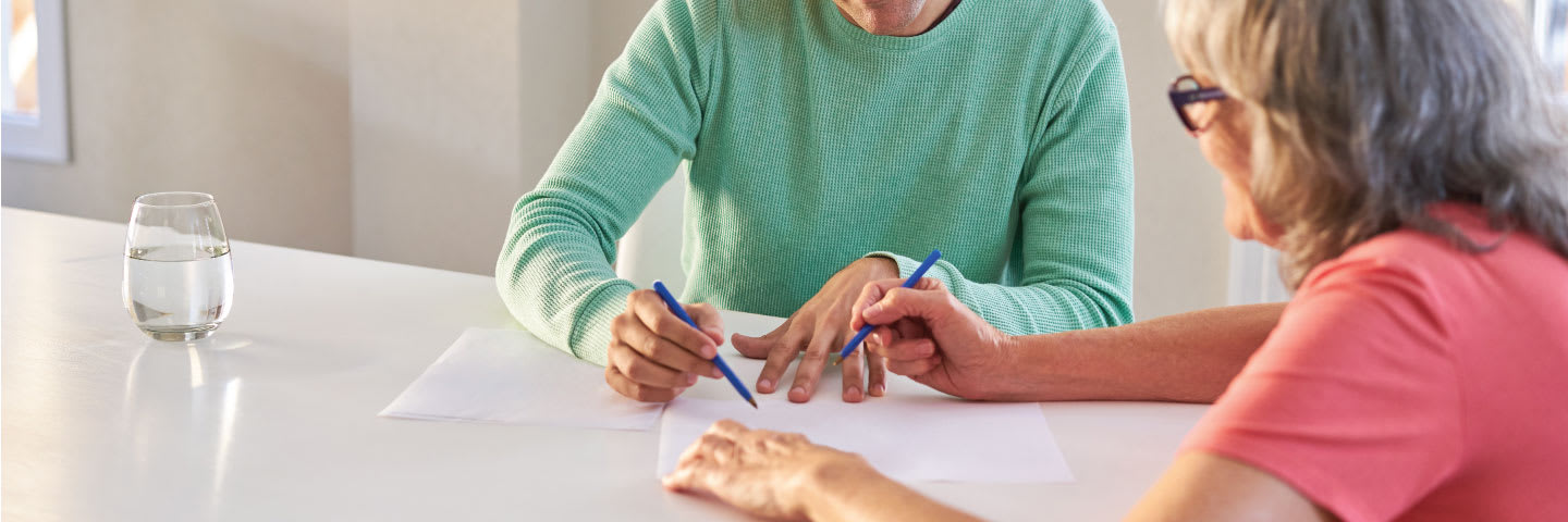 Two senior women review insurance paperwork