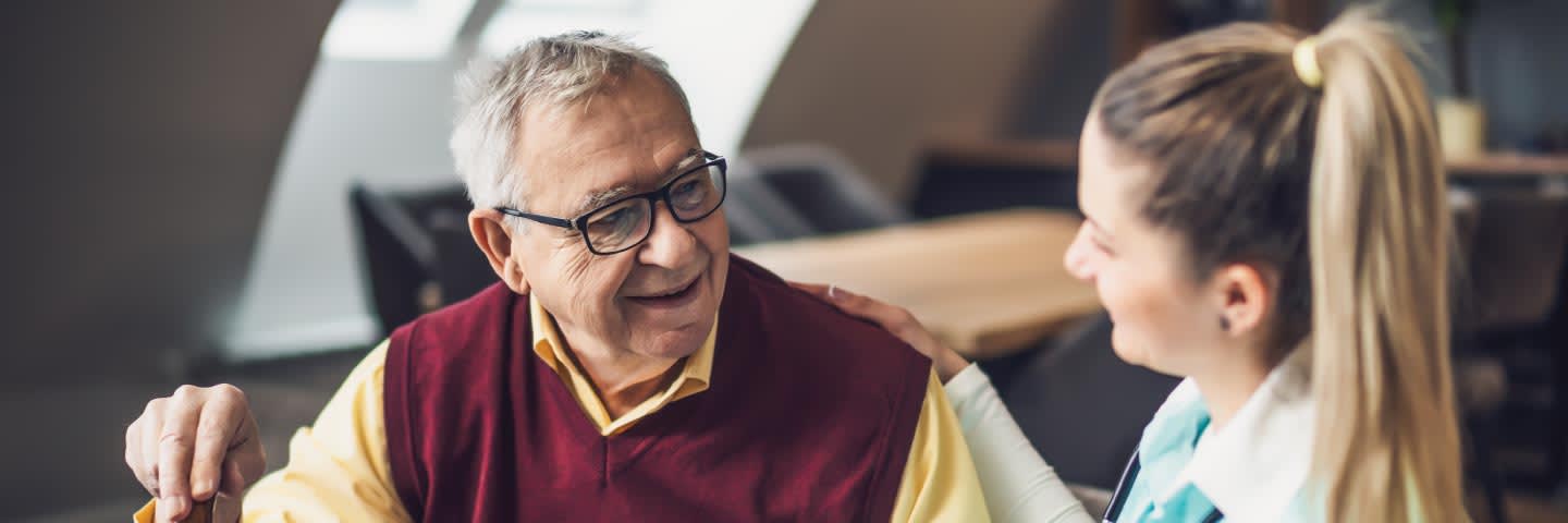 Elderly man talking to care giver