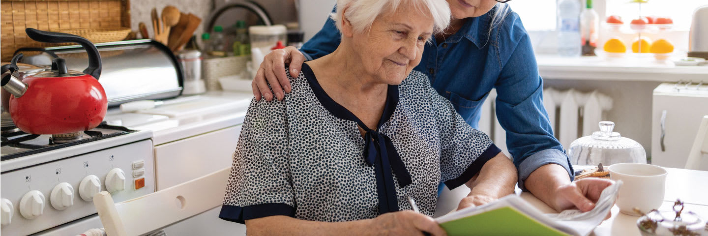 A senior couple reviewing assisted living documents in their kitchen