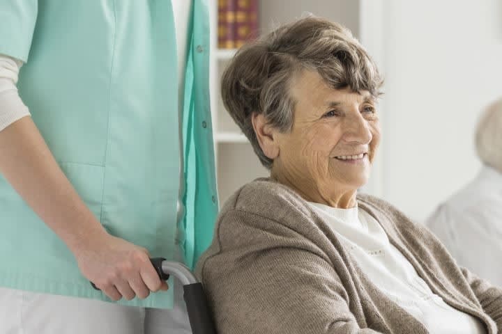 Elderly woman who is smiling in wheelchair.