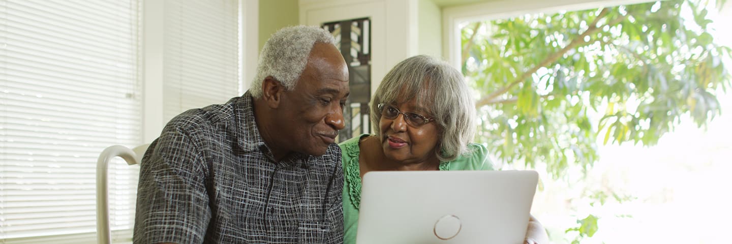 Two seniors looking at a computer together