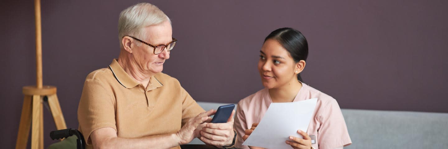 A senior and a caregiver review a document