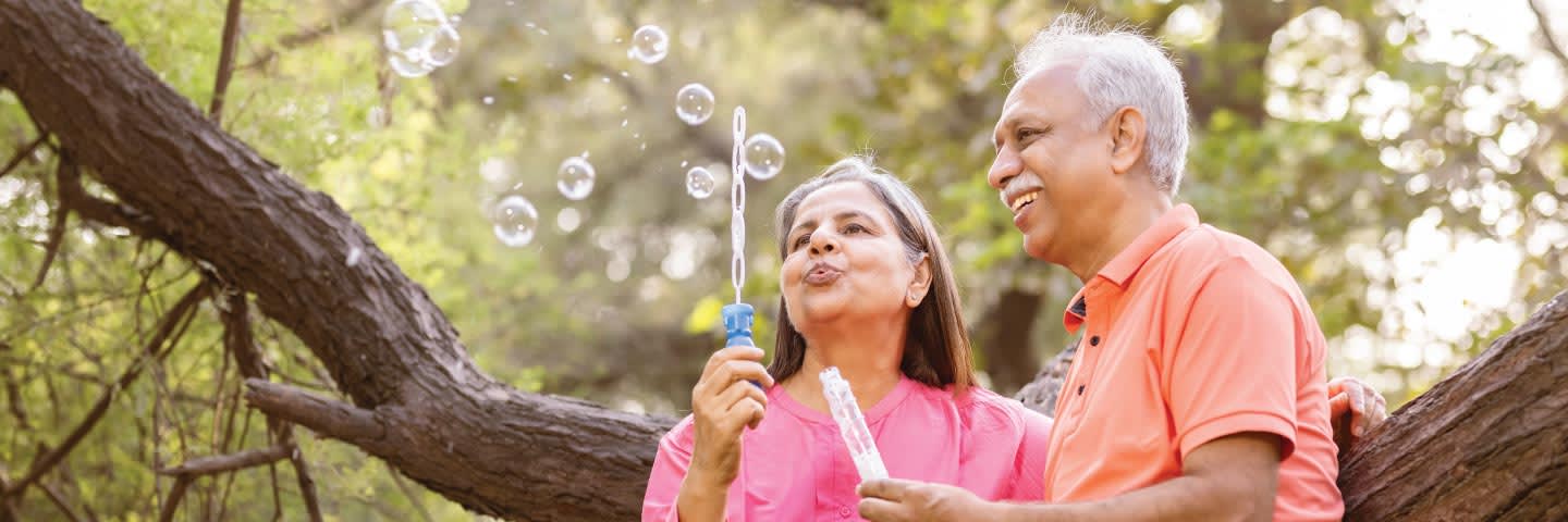 Elderly couple outside blowing bubbles