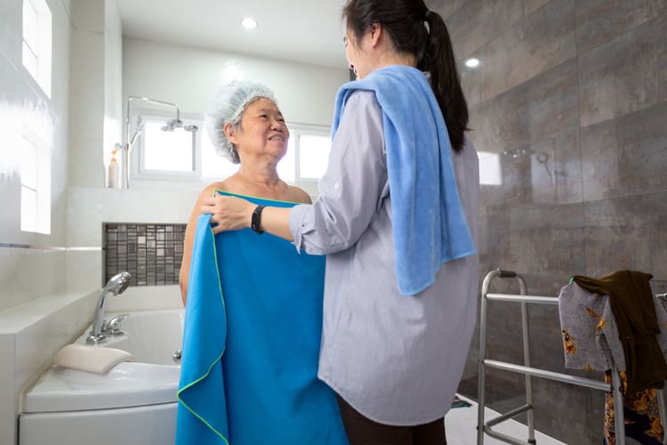 A caregiver bathes a loved one with dementia.