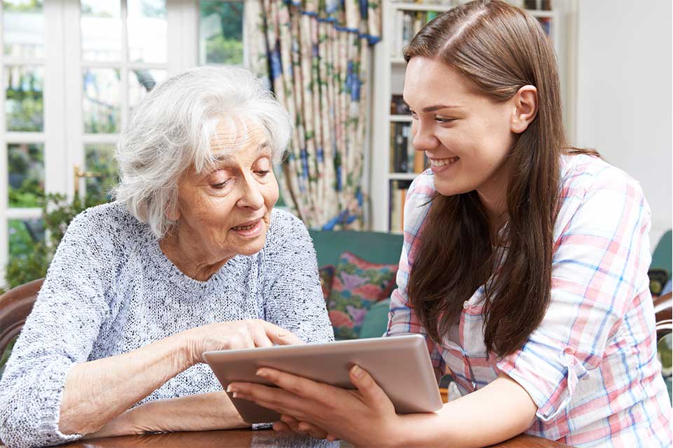 Elderly woman using computer technology to communicate with her loved ones