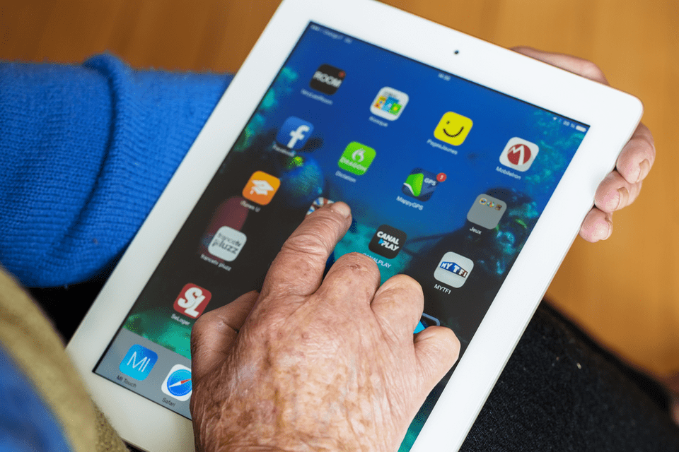 Senior touching an iPad.