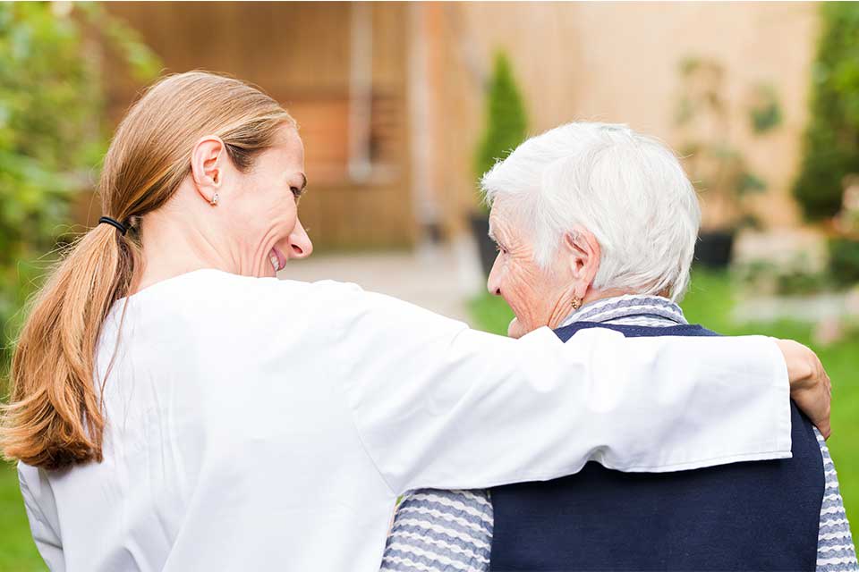 Elderly woman with dementia receiving care from a caregiver.