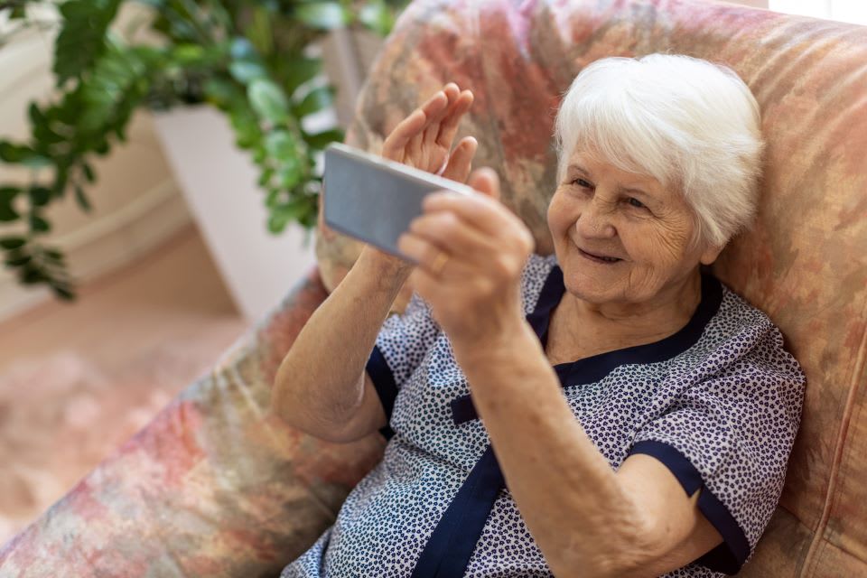 Elderly woman talks on the phone.