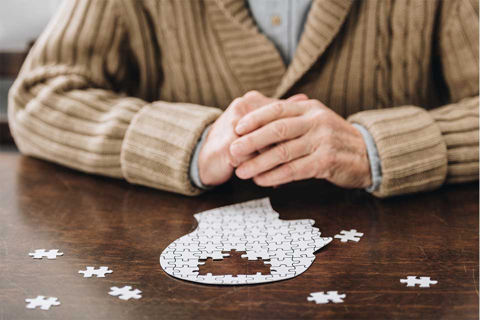 Elderly man with dementia attempting to put together a puzzle