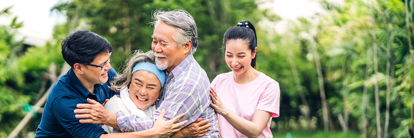 Multigenerational family laughing and hugging outside