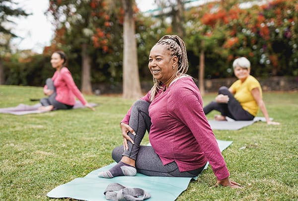 A group of senior women doing stretching exercises outdoors