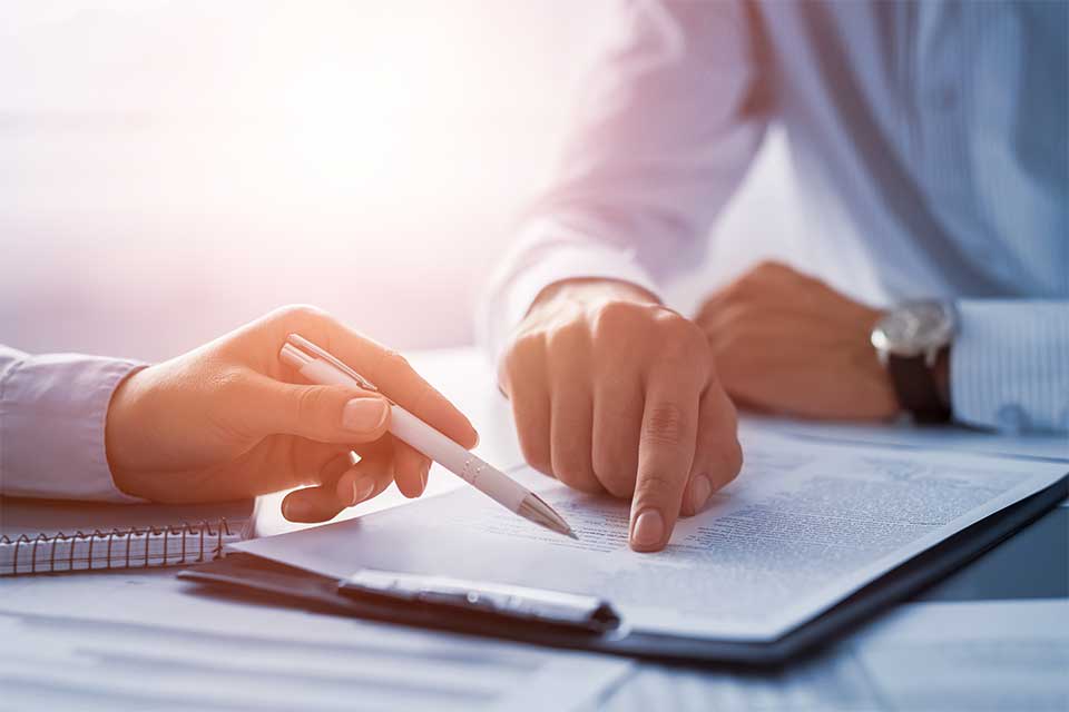 Hands pointing to important points in a power of attorney document.