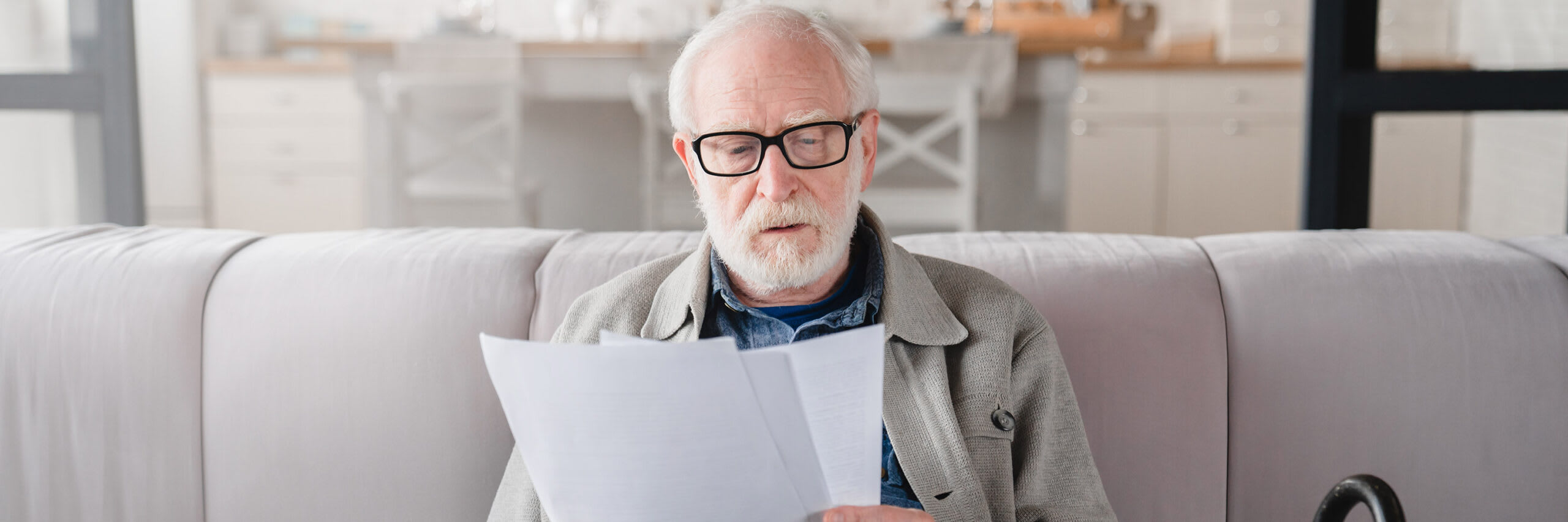 A senior man reviewing paperwork while appearing concerned
