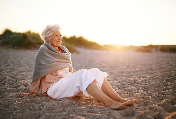 A senior woman relaxing on a Florida beach during a sunset