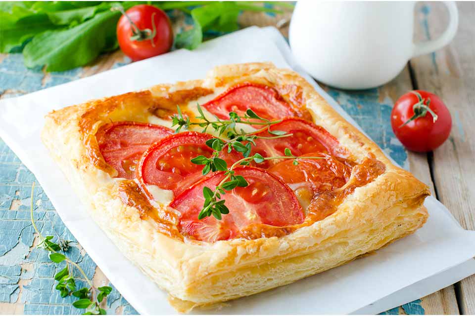 A baked tart with tomatoes on a plate