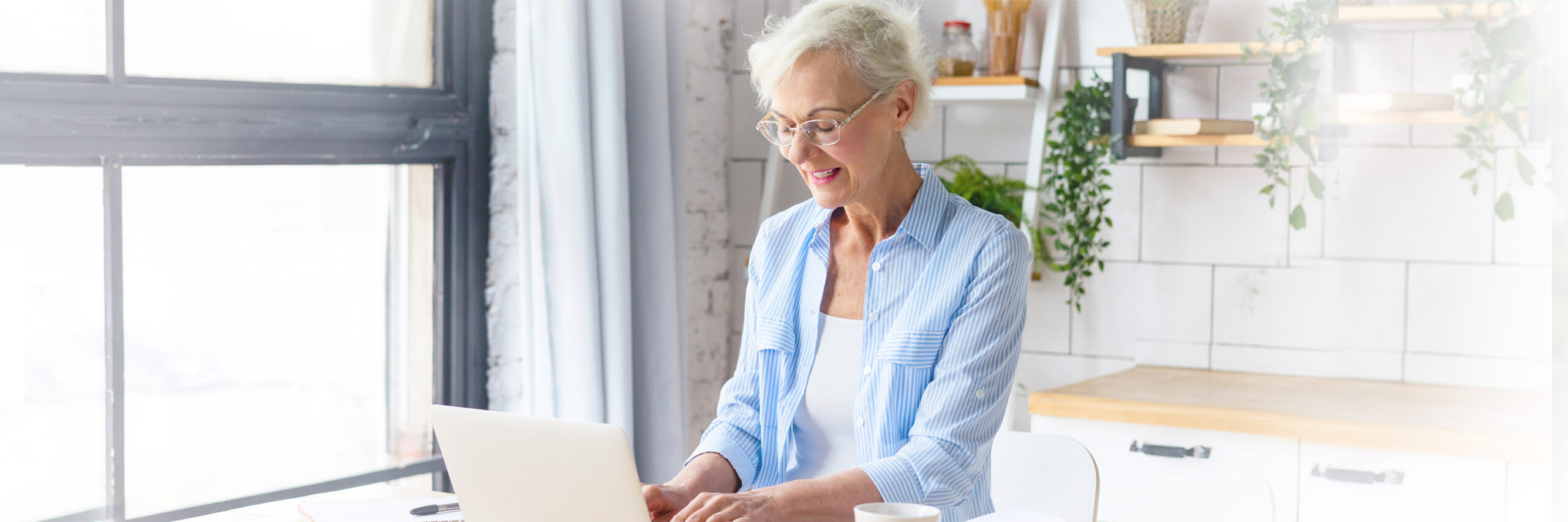 A senior woman at home using a laptop